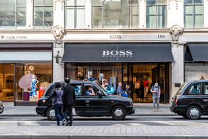 Hugo Boss商店附近城市街道上的黑色的士與行人。