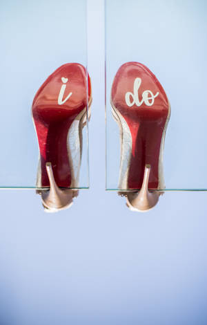 紅色婚禮高跟鞋帶有「i do」文字倒掛。