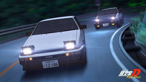 兩輛賽車在彎曲的夜路上疾馳，車頭燈明亮。