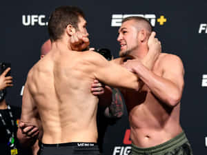 兩名赤裸上身的MMA拳手在UFC賽事中鎖定纏鬥姿勢。