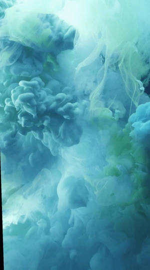 藍色和綠色墨水在水中旋轉，形成流動的抽象圖案。