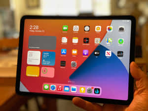 手拿著iPad，顯示帶有應用程式和天氣小工具的主屏幕。