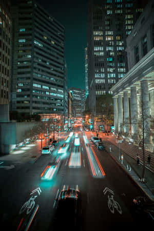 夜晚的城市街道，帶有車燈光軌和高樓大廈。