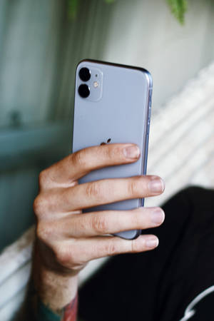 在室內手持銀色 iPhone 11