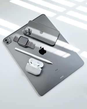 Apple科技產品排列在灰色表面上，明亮的窗戶光線投射出陰影。