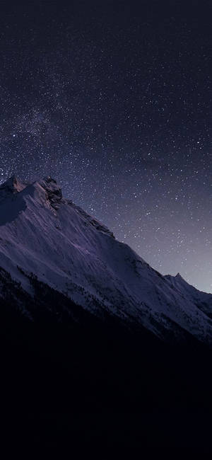 白雪覆蓋的山峰在星空下，銀河清晰可見。
