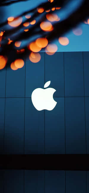 Apple標誌在藍色瓷磚牆上發光，上方有橙色燈光。