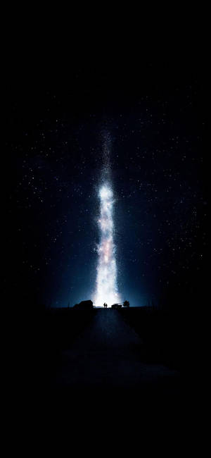 兩人在山頂上觀看明亮的垂直銀河，背景是繁星點點的夜空。