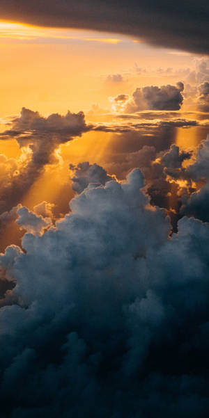 陽光穿過烏雲，在壯麗的日落天空中閃耀。