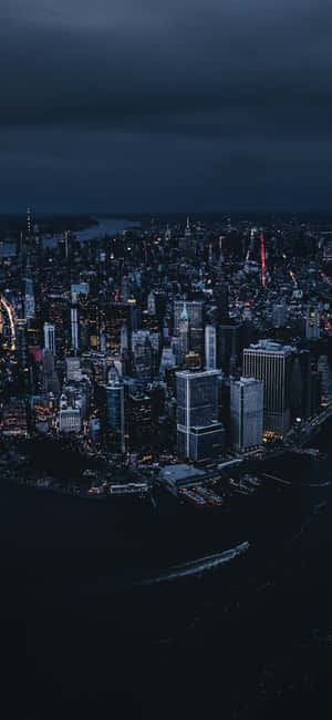 夜間城市景觀，燈火通明的建築物和下方的黑暗水域。