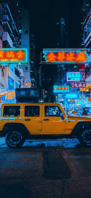 黃色吉普車停喺繁忙亞洲城市夜晚嘅霓虹燈招牌下。