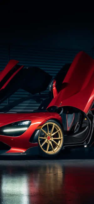在昏暗車庫中，紅色McLaren跑車配備金色輪圈和打開的車門。 — 麥拿侖 GIF 壁紙