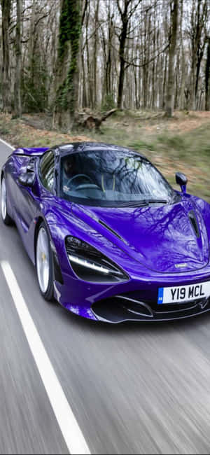 紫色McLaren 720S在森林中疾馳，帶有動態模糊效果。 — 紫色 iPhone 壁紙