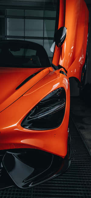 橙色McLaren跑車在車庫中打開鷗翼車門。 — 麥拿侖 GIF 壁紙