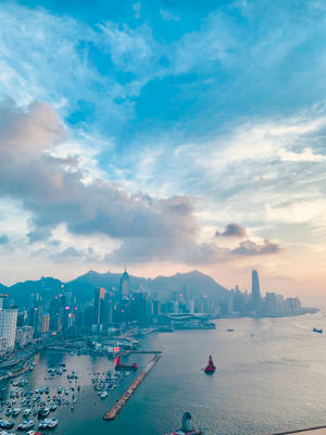 日落時分的香港海港，城市天際線和水面上的船隻。
