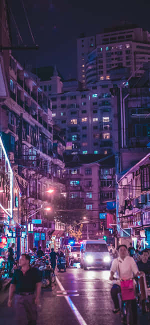夜晚的城市街道，有霓虹燈、行人和車輛。