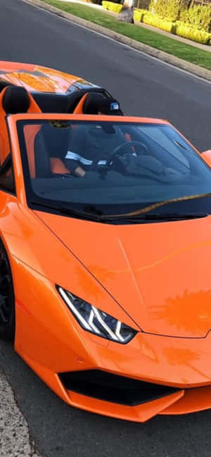橙色林寶堅尼Spyder在陽光明媚的街道上，司機在車內。 — 銀河F07 壁紙