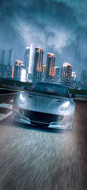 銀色跑車在雨夜中疾馳，穿過燈火通明的摩天大樓。 — Realme Narzo Power 壁紙