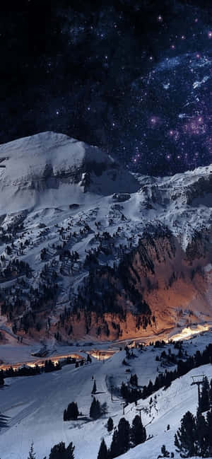 星空下的雪山與閃爍的山谷燈光。 — Moto G 壁紙