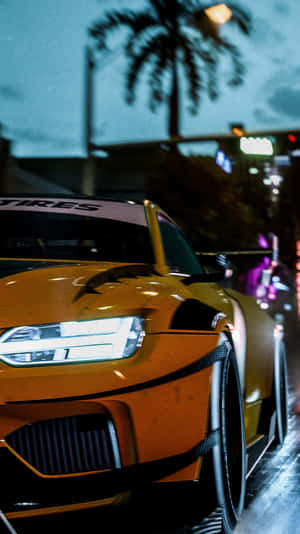 橙色賽車在夜間停放在濕漉漉的城市街道上，在發光的霓虹燈下。