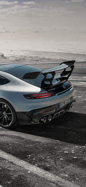 銀色梅賽德斯-AMG GT R跑車停泊在積雪海岸附近的潮濕路上。 — 冬天 壁紙