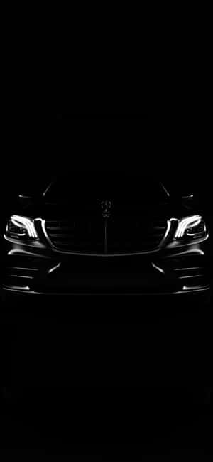 在完全黑暗中發光的豪華車車頭燈和格柵。