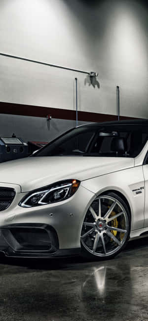 車庫中的銀色 Mercedes-AMG 跑車，配備金色制動器。