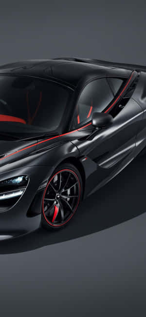 啞光黑色McLaren跑車，帶有紅色飾條和發光的車頭燈，在工作室環境中。 — Honor 500 Pro 壁紙