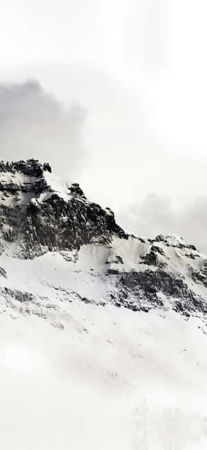 冬季從霧雲中浮現的白雪覆蓋的山峰。
