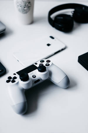 乾淨桌子上的白色遊戲手掣，附有電話和耳機。