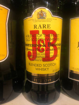 豪華威士忌酒瓶特寫，黃色標籤和皇家徽章。
