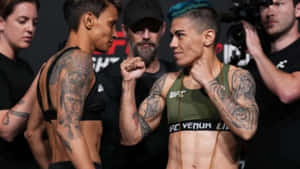 兩名女MMA拳手帶住紋身同UFC裝備喺比賽前互相凝視。