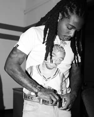 留辮子男人調整皮帶身穿Tupac T恤