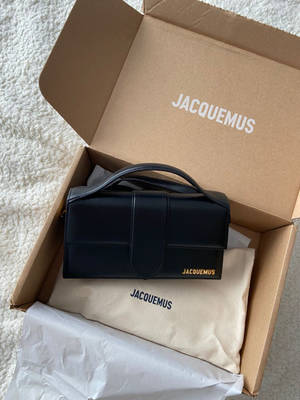 黑色Jacquemus手袋在品牌盒子內，置於白色地毯上