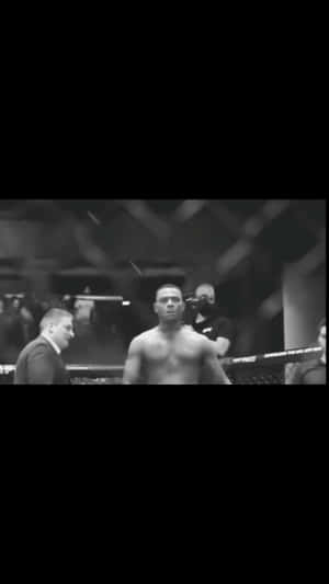 一名赤裸上身的MMA拳手在八角籠中面對一名西裝男。