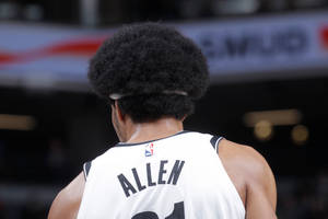 籃球運動員Allen在球場上從背後看，穿著白色球衣。
