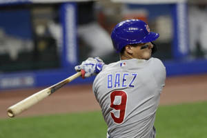 棒球運動員Baez 9號在夜間比賽中揮棒。
