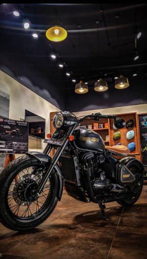 黑色 Royal Enfield 摩托車在現代室內展廳中展示，配有溫暖的燈光和木架。