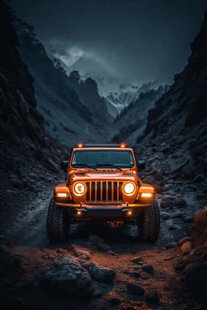 一輛橙色吉普車亮著車頭燈，在夜晚的岩石山谷中行駛，頭頂是風暴雲層。