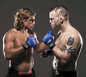 兩名赤裸上身的MMA拳手戴著藍色手套，以緊張的攝影棚姿勢對峙。