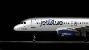 夜間在停機坪上亮起星際大戰標語的jetBlue飛機。