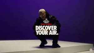 人物身穿黑色Foot Locker裝備蹲在紫色背景前，帶有「Discover Your Air」文字。