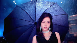 女性在藍色燈光下雨中撐著閃閃發光的黑色雨傘。