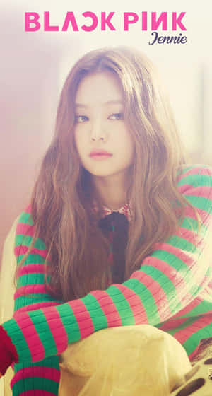 K-pop藝人Jennie穿著粉紅和綠色條紋毛衣看著鏡頭。