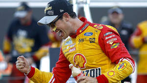 NASCAR車手握緊拳頭並手持可口可樂瓶慶祝勝利。