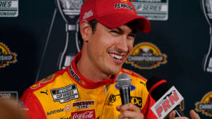 NASCAR車手在記者會上微笑，面前有麥克風。