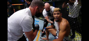 UFC拳手在八角籠受傷後接受醫療護理。