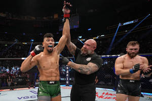UFC拳手贏得比賽，裁判在八角籠內舉起他的手。