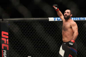 UFC拳手在八角籠內高舉拳頭慶祝勝利。