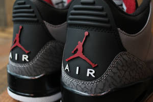 黑色Jordan Air運動鞋，帶有紅色標誌和大象紋理。